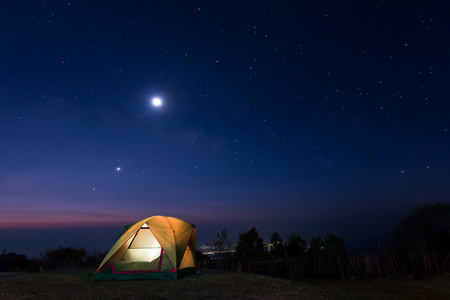野营帐篷在夜晚的星空下照片