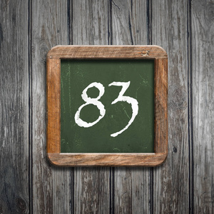 83数字83在绿色黑板在木背景之上摄影图