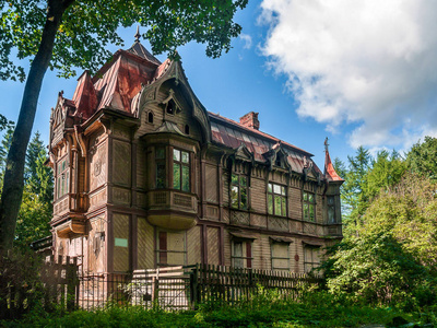 一幢两层楼的木制建筑, 建于 1902年, 里面有炮塔海湾窗户在铁皮屋顶上的烟囱在圣彼得堡的舒瓦洛夫公园有大阁楼窗户。