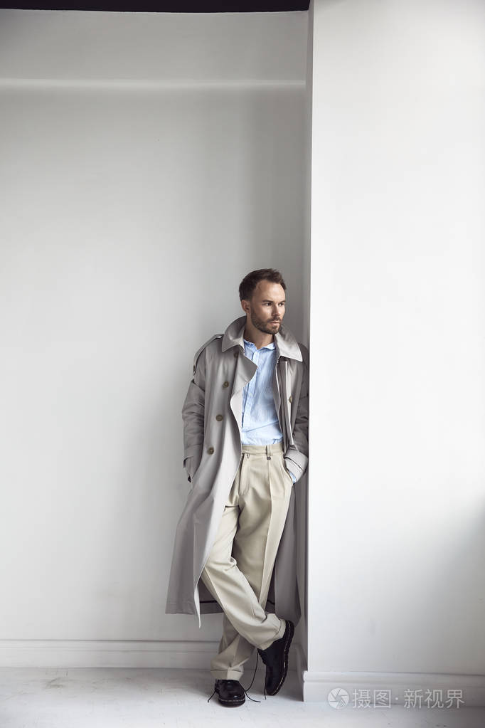 时尚肖像的英俊男子与深色胡子和头发, 穿着在浅色风