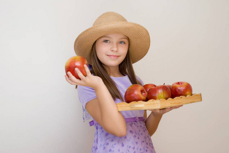 戴草帽的小女孩拿着红苹果盘子