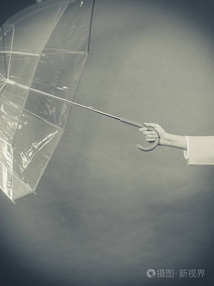 女人手拿着透明开放把伞.工作室拍摄黑暗的背景