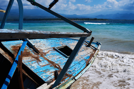 美丽的热带海滩与旧废弃的木船上湛蓝清澈的水背景。海景色惊人的自然背景。水的颜色和美丽的明亮。选择性聚焦