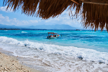 珊瑚海的老式木制小船。沙滩上蔚蓝的海浪。旅行和放松的梦想岛。海景色惊人的自然背景。水的颜色和美丽的明亮