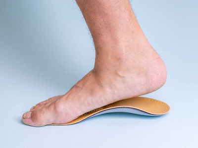 一个男人的右腿, 用结实的扁平脚试着矫形鞋垫。腿部和关节疾病