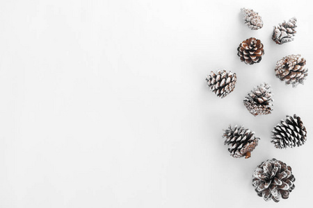 圣诞松树锥上的白色纸边框组成。创意平躺, 顶视图设计