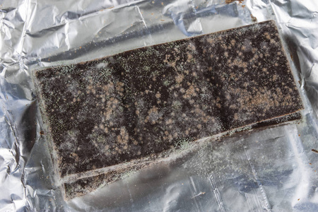 过期食品发霉的巧克力在原来的包装.用于甜点的过期食品.白色背景照片