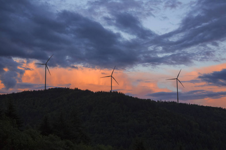 风力涡轮机在 Gersbach 附近的树木繁茂的山上, 在黄昏的阳光下黑森林