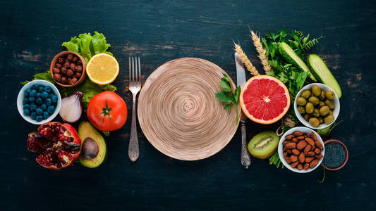 健康食品的清洁饮食选择 蔬菜, 水果, 坚果, 浆果和蘑菇, 欧芹, 香料。在黑色背景上。文本的可用空间
