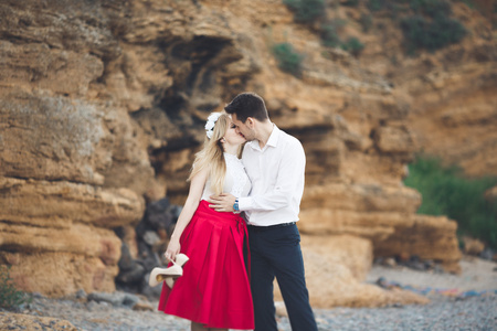 浪漫恩爱的夫妻，用石头和岩石海滩上散步，