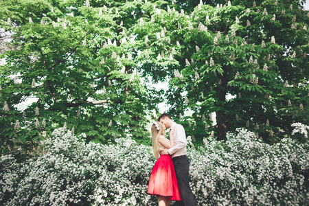 时尚美丽快乐婚礼情侣接吻和拥抱在植物园照片