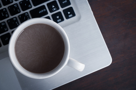咖啡杯放在笔记本电脑上
