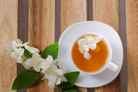 顶视图的一杯茶与茉莉花和一张木桌一枝