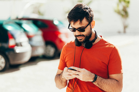 人听音乐与他的智能手机在街上图片