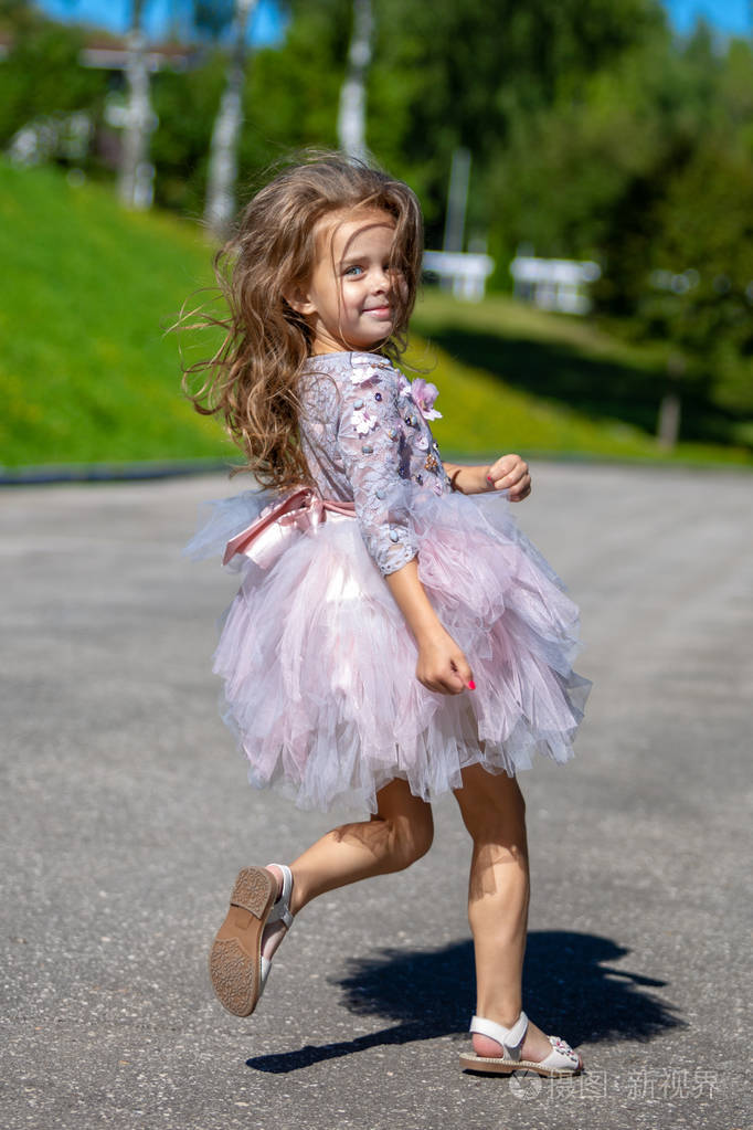 一个美丽的小女孩在户外的豪华长发的肖像.运行子级