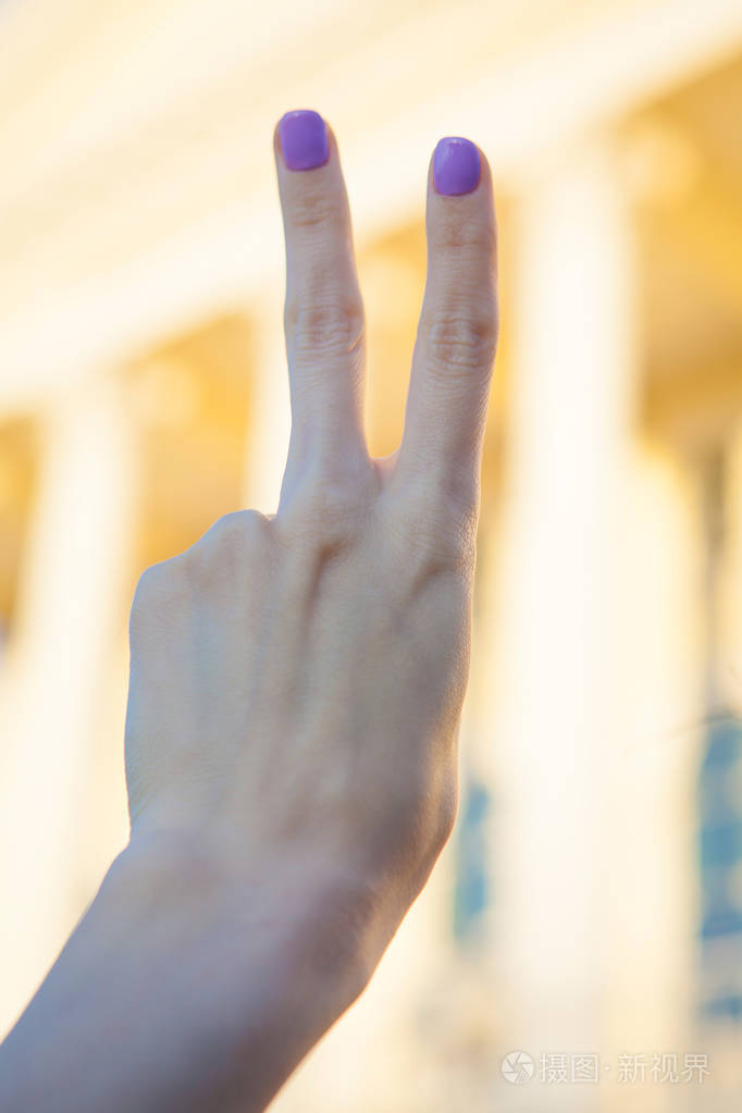 女人举起两个手指在手上它是显示和平力量战斗或胜利标志和字母 v 在