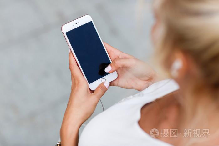 他手里拿着手机的女孩照片-正版商用图片0s4qfx-摄图新视界