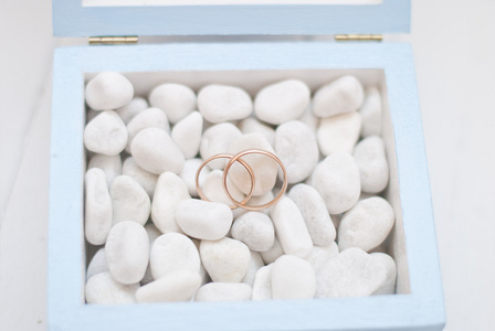 与白色石头的蓝盒子里的结婚戒指。婚礼仪式
