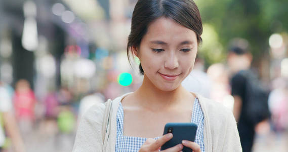 女人在街上使用手机