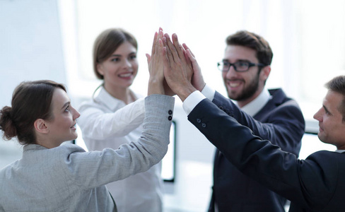 站在办公室快乐的成功业务团队给击掌手势作为 th商务团队成功之手给