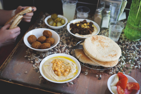 以色列在耶路撒冷的咖啡馆里吃了一顿以色列午餐。Falafels 在一个盘子上, 奶油鹰嘴豆与整个 cheakpeas, 皮塔饼和