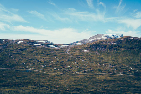 挪威北部农村的全景与 Jotunheimen 国家公园山顶部在背景。许多传统小屋在谷