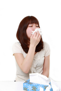 过敏打喷嚏到组织中的年轻女子照片