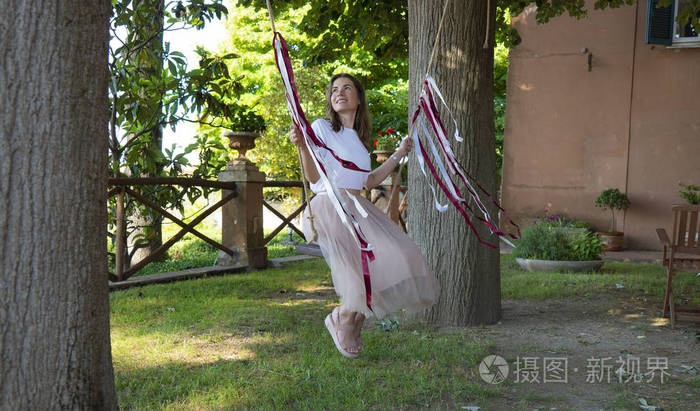 在院子里荡秋千的漂亮女孩