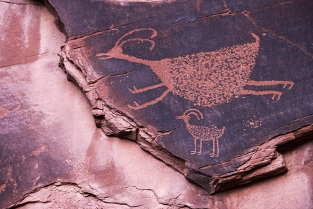 著名的 Anasazi 岩画代表两个动物雕刻在纪念碑谷纳瓦霍部落公园的砂岩悬崖, 犹他州, 美国
