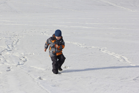 孩子在冬天在雪地上奔跑的颜色夹克