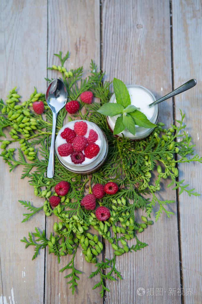 酸奶配新鲜树莓木制背景上。健康早餐