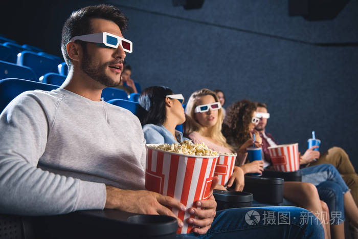 多民族朋友的选择性焦点在3d 眼镜与爆米花一起看电影在电影院