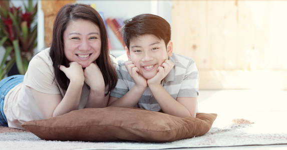 亚洲家庭的母亲和儿子的肖像看着笑脸的相机