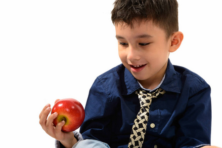 工作室拍摄的可爱的快乐男孩微笑着拿着红苹果