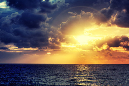 美丽明亮多彩绚丽的海日落, 太阳在云层中的阳光戏剧性日落越过海洋