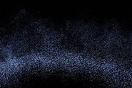黑色背景下的蓝色溅水。白色粒子的冻结运动。雨, 雪覆盖纹理