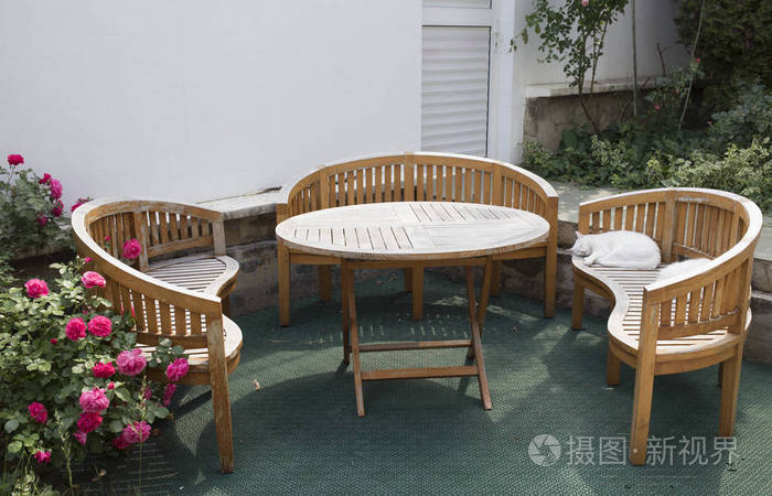 非常好设计的天井区域 这是后院的石头白墙 放松的地方与舒适的户外家具和盛开的玫瑰花照片 正版商用图片0s64vd 摄图新视界
