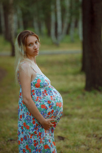 怀孕的女孩在公园散步