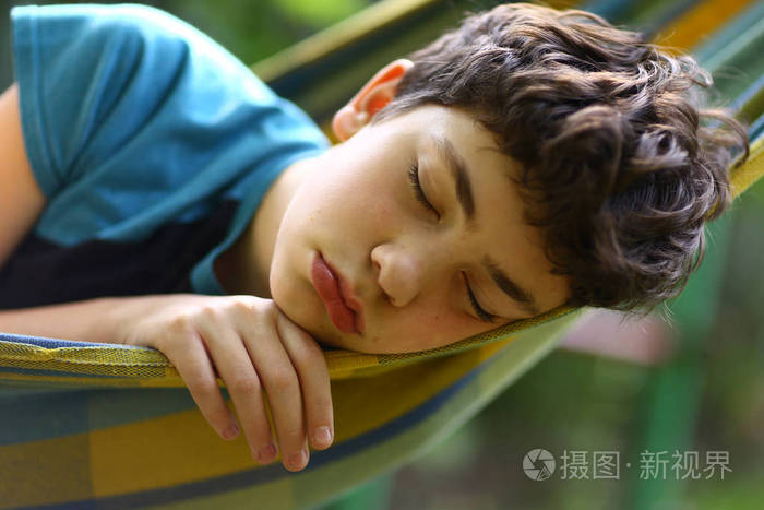 少年男孩睡在吊床上