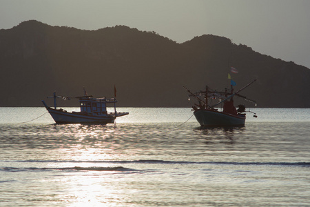 传统的小船在一个早晨，日出铺设的大海与久大的山，光波面上 Prachuapkhirikhan 泰国