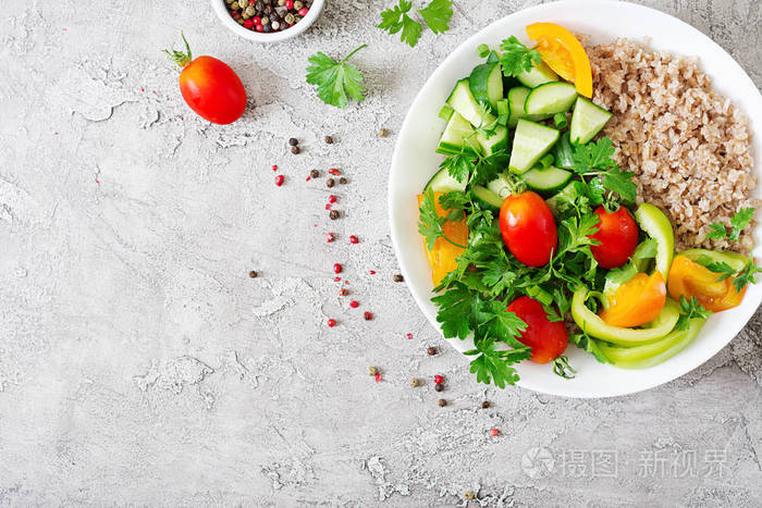 节食菜单。健康素食沙拉, 新鲜蔬菜西红柿, 黄瓜, 甜椒和碗粥。纯素食的食物。平躺。顶部视图