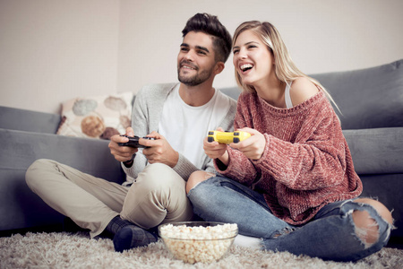 俏皮的年轻夫妇在他们的客厅里玩视频游戏
