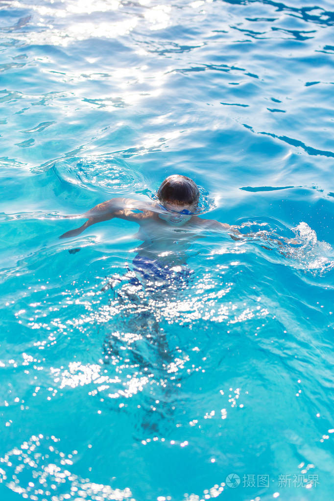 年轻滑稽的孩子潜水在游泳池室外