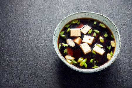 日本味噌汤在陶瓷碗上黑石桌上, 复制空间。亚洲豆腐汤