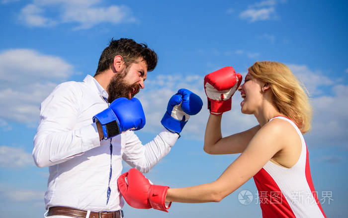 男人和女人打拳击手套蓝天背景.在对抗中捍卫你的观点.