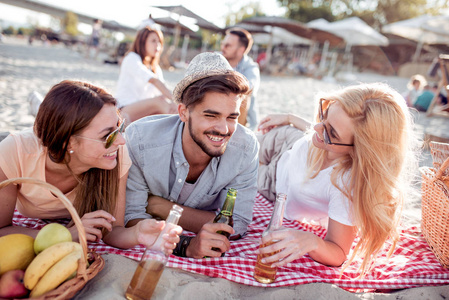 夏季, 节假日, 旅游和人的概念小组的微笑的朋友在海滩上的啤酒瓶无比