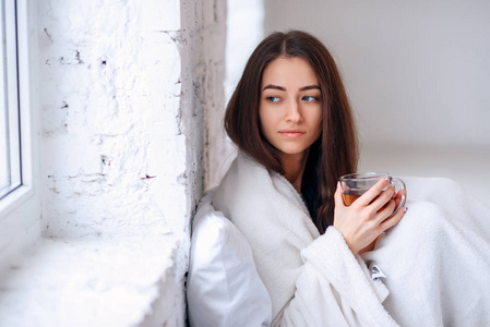 在温暖的格子里, 手里拿着热杯茶, 把漂亮的年轻女人合上。疾病和疾病。生病不健康的女性饮用温暖的饮料室内