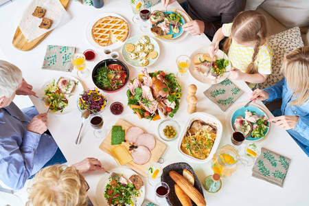 就在庆祝活动期间, 大幸福家庭坐在餐桌上享用美味的自制食物的全景