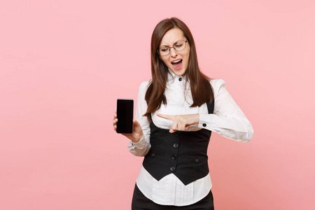 年轻关心的企业妇女拿着, 指向食指在移动电话与空白空的屏幕被隔绝在粉红色背景。老板娘成就事业财富。复制广告空间