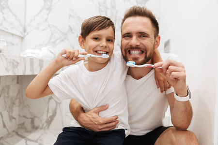 幸福的父亲的形象30s 和儿子810 微笑和清洁的牙齿一起在浴室